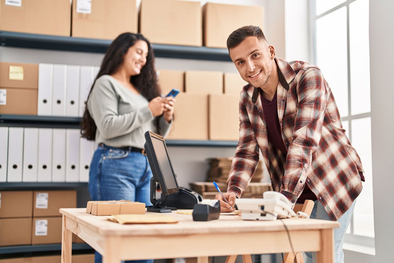 Dos emprendedores atendiendo los pedidos de su tienda